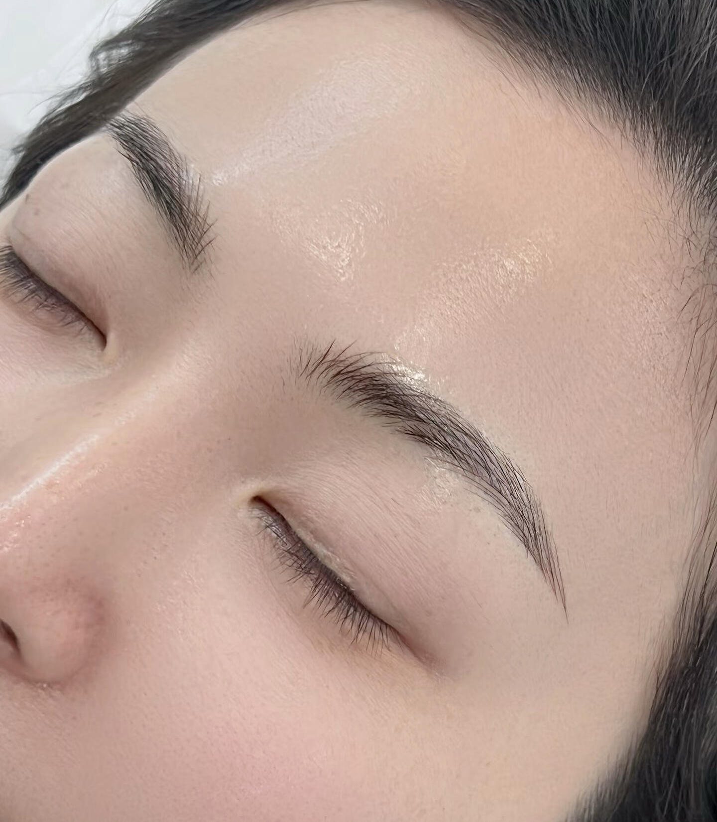 Natural Feathered Eyebrows with Microblading Technique Detailed view of microbladed eyebrows with natural, feathered strokes.